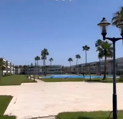 a street light next to a park with palm trees at Résidence balnéaire casablanca in Dar el Maïzi