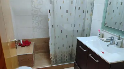a bathroom with a shower with a sink and a toilet at Résidence balnéaire casablanca in Dar el Maïzi
