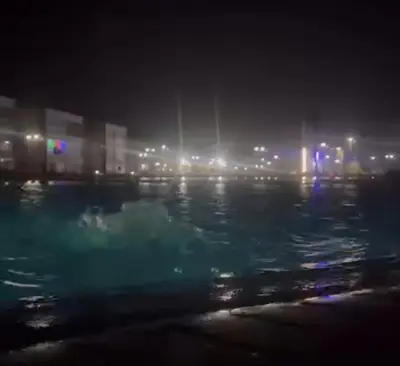 a nightime view of a swimming pool in a city at Résidence balnéaire casablanca in Dar el Maïzi