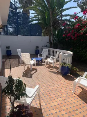 a group of white chairs sitting on a patio at Riad JOUHARA in Skhirat
