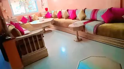 a living room with a couch with pink pillows at Wifa9 in Temara