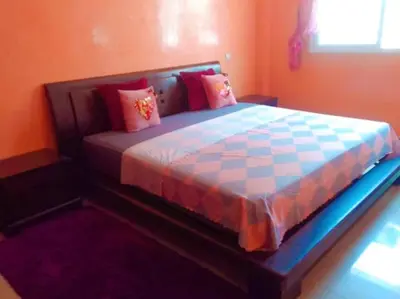 a bedroom with a large bed with colorful pillows at Wifa9 in Temara