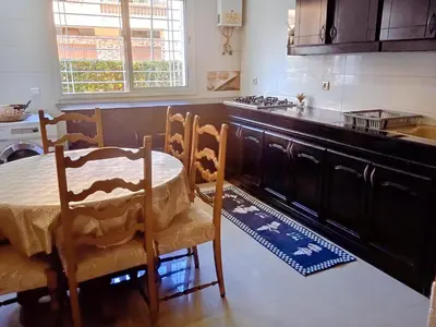 a kitchen with a table and chairs and a stove at Wifa9 in Temara