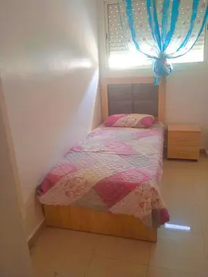 a small bedroom with a bed with a window at Wifa9 in Temara