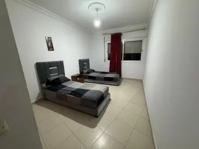 a room with two beds and a couch and a window at Martil in Anfa-Supérieur