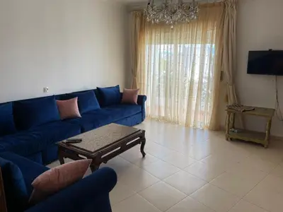a living room with a blue couch and a table at Martil in Anfa-Supérieur