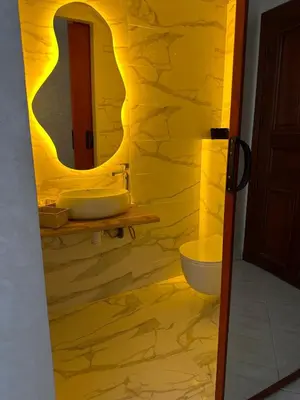 a yellow bathroom with two sinks and a mirror at Apartment in Casablanca Maarif in Casablanca