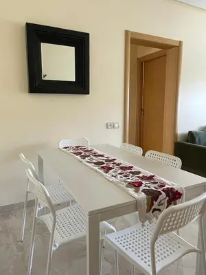 a white table with chairs and a blanket on it at lumineux appartement in Bouznika