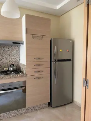 a kitchen with a stainless steel refrigerator and a stove at lumineux appartement in Bouznika
