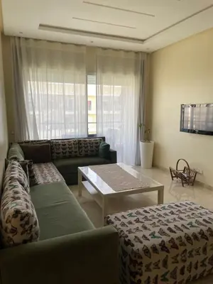 a living room with a couch and a table at lumineux appartement in Bouznika