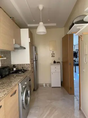 a kitchen with a washer and dryer in it at lumineux appartement in Bouznika