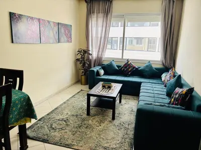 a living room with a blue couch and a table at Havre de paix au centre de Casablanca in Casablanca
