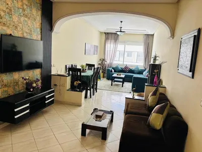 a living room with a couch and a tv at Havre de paix au centre de Casablanca in Casablanca