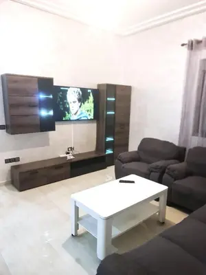 a living room with a couch and a tv at Beau appartement pour votre séjour a Casablanca Bouskoura in Bouskoura