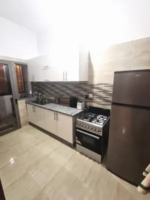 a kitchen with a stove and a refrigerator at Beau appartement pour votre séjour a Casablanca Bouskoura in Bouskoura