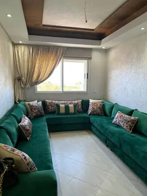 a large green couch in a room with a window at Détente et confort en face de mer in Casablanca