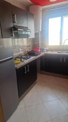 a kitchen with black cabinets and a stove top oven at Détente et confort en face de mer in Casablanca