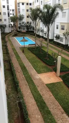 a pathway leading to a swimming pool in a building at Détente et confort en face de mer in Casablanca