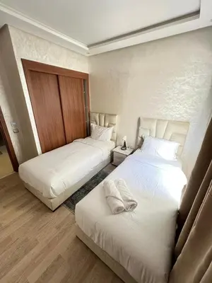 two beds in a room with white sheets at M4 Spacious Appartment in Exclusive Residence by the Sea in Rabat