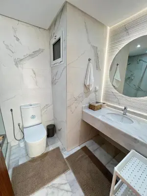 a bathroom with a toilet and a sink and a mirror at M4 Spacious Appartment in Exclusive Residence by the Sea in Rabat