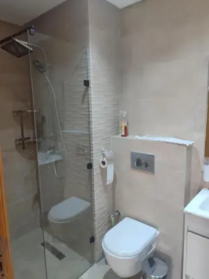 a bathroom with a toilet and a glass shower at CASABLANCA BORD dE MER A 200 m DE LA PLAGE Appartement Haut de gamme 2 Chambres avec 2 Salles de bain Piscine Salle de Sport plage in Casablanca