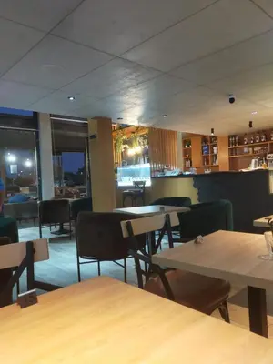 a restaurant with tables and chairs and a bar at CASABLANCA BORD dE MER A 200 m DE LA PLAGE Appartement Haut de gamme 2 Chambres avec 2 Salles de bain Piscine Salle de Sport plage in Casablanca
