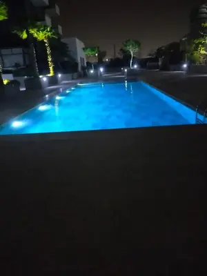 a large blue swimming pool at night at CASABLANCA BORD dE MER A 200 m DE LA PLAGE Appartement Haut de gamme 2 Chambres avec 2 Salles de bain Piscine Salle de Sport plage in Casablanca