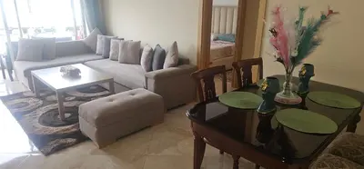a living room with a couch and a table at Appartement vue sur piscine kettani in Bouznika