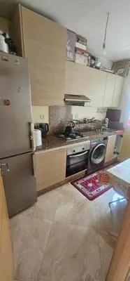 a kitchen with a refrigerator and a stove top oven at Appartement vue sur piscine kettani in Bouznika