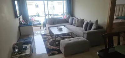 a living room with a couch and a table at Appartement vue sur piscine kettani in Bouznika