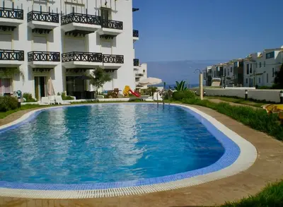 a large swimming pool in front of a building at Sun Darb in Dar Bouazza