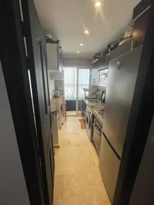 a kitchen with a refrigerator and a stove top oven at Sun Darb in Dar Bouazza