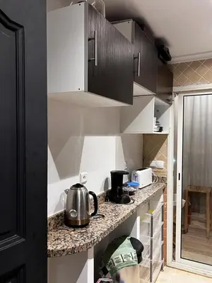 a kitchen with white cabinets and a tea kettle on a counter at Sun Darb in Dar Bouazza