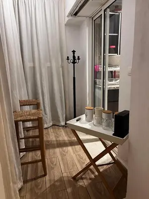 a table and a chair in a room with a window at Sun Darb in Dar Bouazza