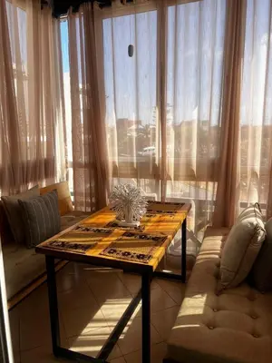 a living room with a table and a couch at Sun Darb in Dar Bouazza