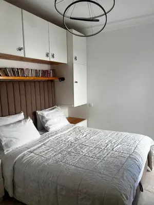 a bedroom with a large bed and a chandelier at Sun Darb in Dar Bouazza