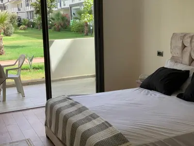 a bedroom with a bed and a view of a yard at Dar Bouazza Plage in Dar Bouazza