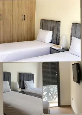 a couple of beds in a room with a tv at Dar Bouazza Plage in Dar Bouazza