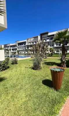 a large apartment building with a grassy yard in front of a building at Dar Bouazza Plage in Dar Bouazza