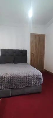 a bedroom with a bed and a wooden cabinet at Appartement calme absolu in Casablanca
