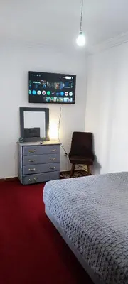 a bedroom with a bed and a tv and a chair at Appartement calme absolu in Casablanca