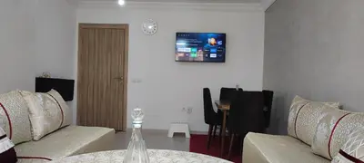a living room with two couches and a tv on the wall at Appartement calme absolu in Casablanca