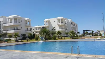 a swimming pool in front of some apartment buildings at Bahía Golf Beach BOUZNIKA in Bouznika
