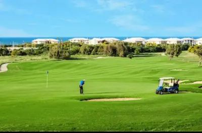a man is playing golf on a golf course at Bahía Golf Beach BOUZNIKA in Bouznika