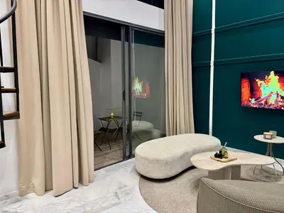 a living room with a couch and a tv at Duplex franceville in Casablanca