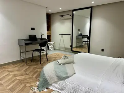 a bedroom with a bed and a desk and a mirror at Duplex franceville in Casablanca