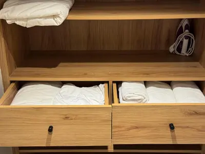 a wooden cabinet filled with white towels and towels at Duplex franceville in Casablanca