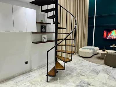 a spiral staircase in a living room with a couch at Duplex franceville in Casablanca
