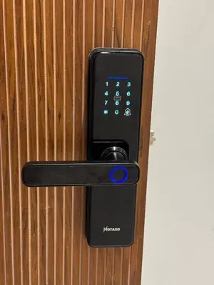 a remote control on a doorhandle on a wooden door at Duplex franceville in Casablanca