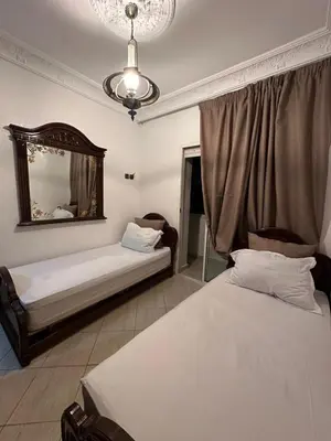 a bedroom with two beds and a mirror at Calme, plage 8 min, tout proche in Temara